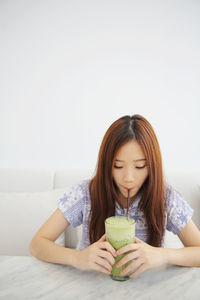 Portrait of a young woman drinking drink