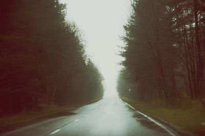 Road amidst trees against sky