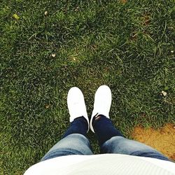 Low section of person standing on grassy field