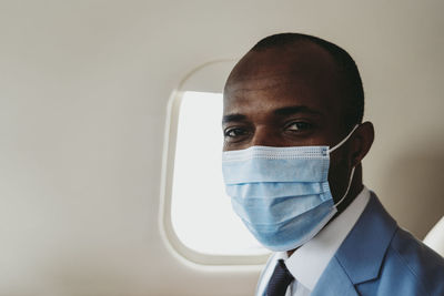 Businessman with protective face mask in private jet