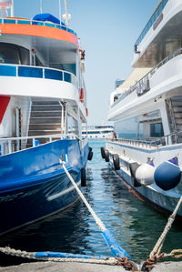 Boats moored in sea against blue sky