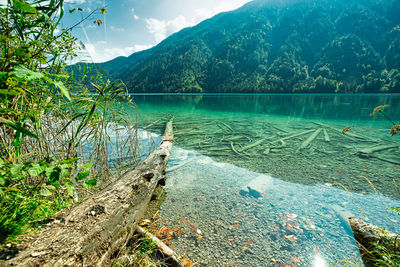 Scenic view of lake by mountains against sky