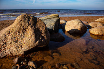 Rocks on beach against sky