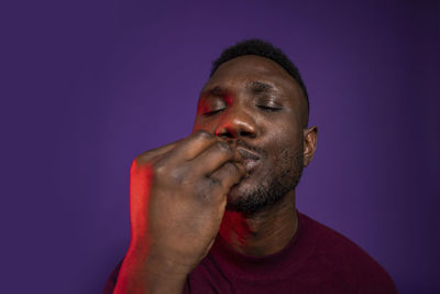Portrait of young man against blue background