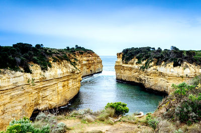 Rock formations by sea against sky