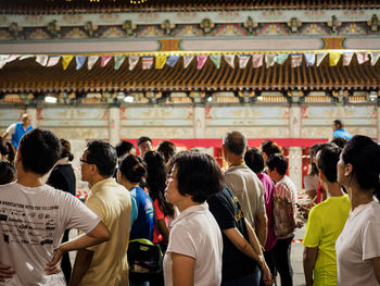 Rear view of people standing outside temple