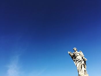 Low angle view of statue against clear blue sky