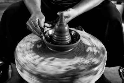 Cropped hands making pottery