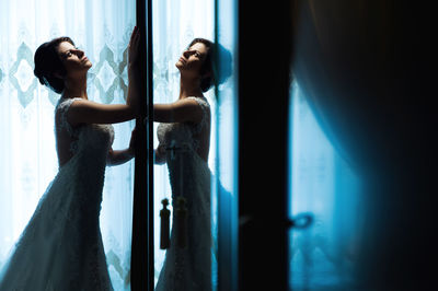 Bride standing by mirror with reflection