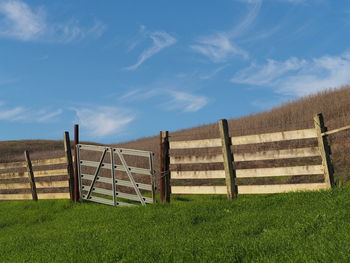 Fence on landscape against sky