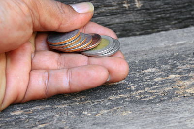 Cropped hand of man holding coins at table