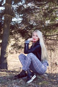 Portrait of beautiful young woman sitting on land