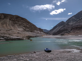 Scenic view of lake by mountains against sky