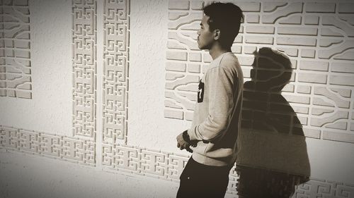 Man and woman standing against wall