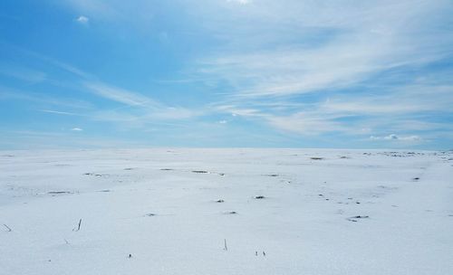 Scenic view of snow covered land against sky