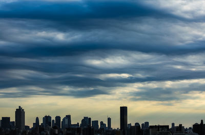 View of cityscape against cloudy sky