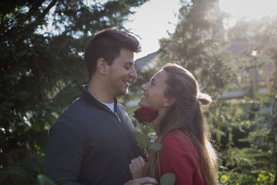 Young couple kissing against plants