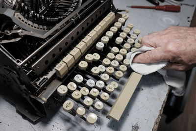 Cropped hand cleaning typewriter