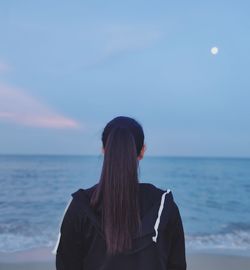 Rear view of woman looking at sea against sky