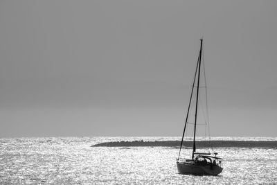 Boat sailing in sea against clear sky