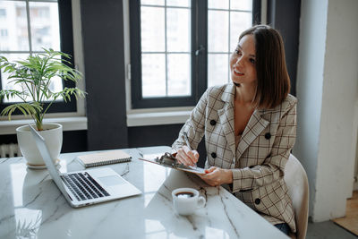 Young businesswoman using laptop at office