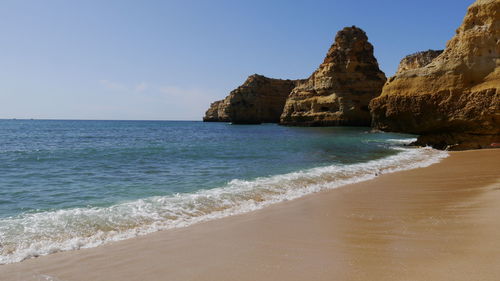 Typical shore of algarve, portugal wirh beautiful sandy beach and rock formation