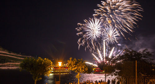 Firework display over river at night