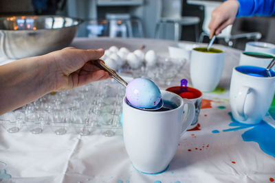 Midsection of person holding ice cream on table