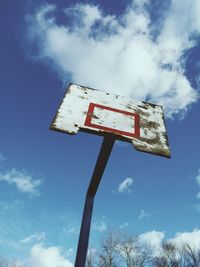 Low angle view of abandoned basketball hoop against blue sky