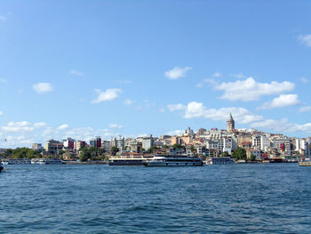 Sea by buildings against sky in city