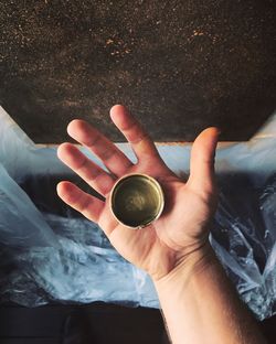 High angle view of hand holding coffee cup