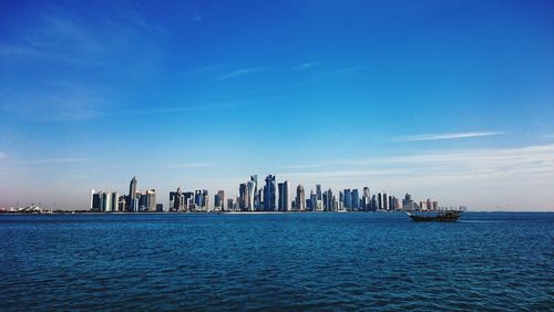 Scenic view of sea and city skyline against clear sky