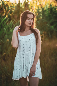 Young woman standing against plants