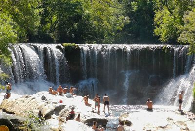 Group of people on rocks against trees