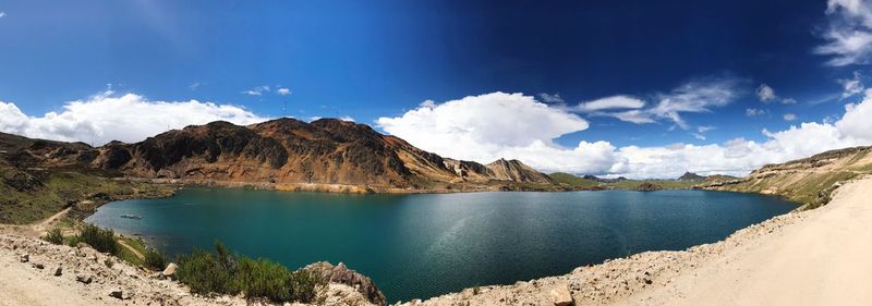 Panoramic view of lake and mountains against blue sky