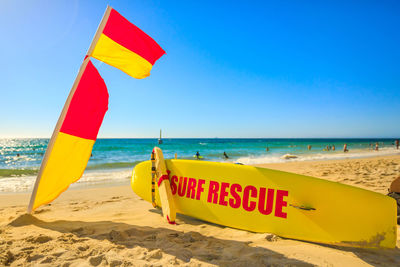 Information sign on beach against clear sky