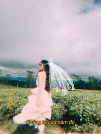 Woman standing on field against sky