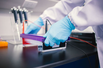 Laboratory assistant putting test tubes into the holde