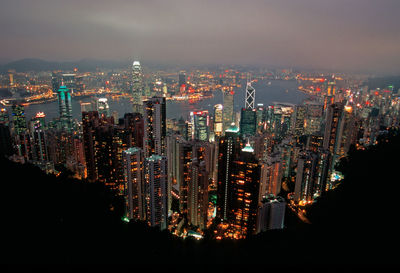 Illuminated cityscape against sky at night