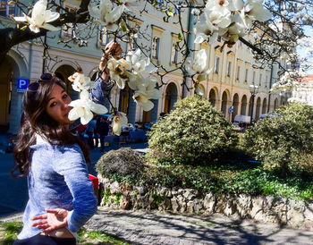 Full length of woman standing by flowering plants