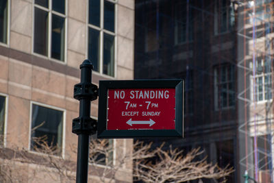 Low angle view of information sign against building