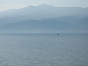 Scenic view of sea and mountains against sky