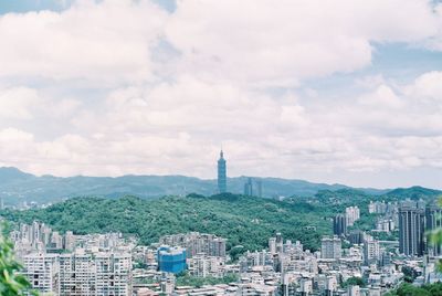 Buildings in city against cloudy sky