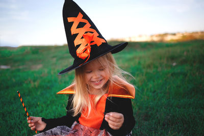 Portrait of smiling girl holding umbrella on field