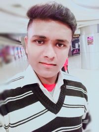 Portrait of young man standing at home