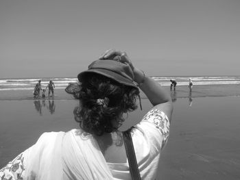 Rear view of woman looking at sea against clear sky