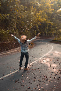 Man scattering dry leaves