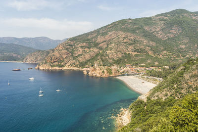 High angle view of sea and mountains against sky