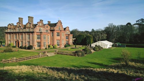 Castle by houses against sky