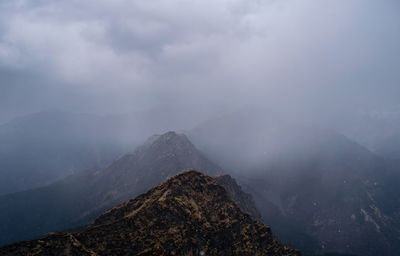 Scenic view of mountains against sky during foggy weather